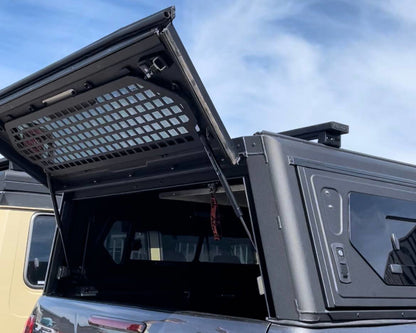 Grille de sécurité pour fenêtre arrière Alu-Cab Contour en aluminium, protection maximale, accessoire robuste pour véhicule tout-terrain.