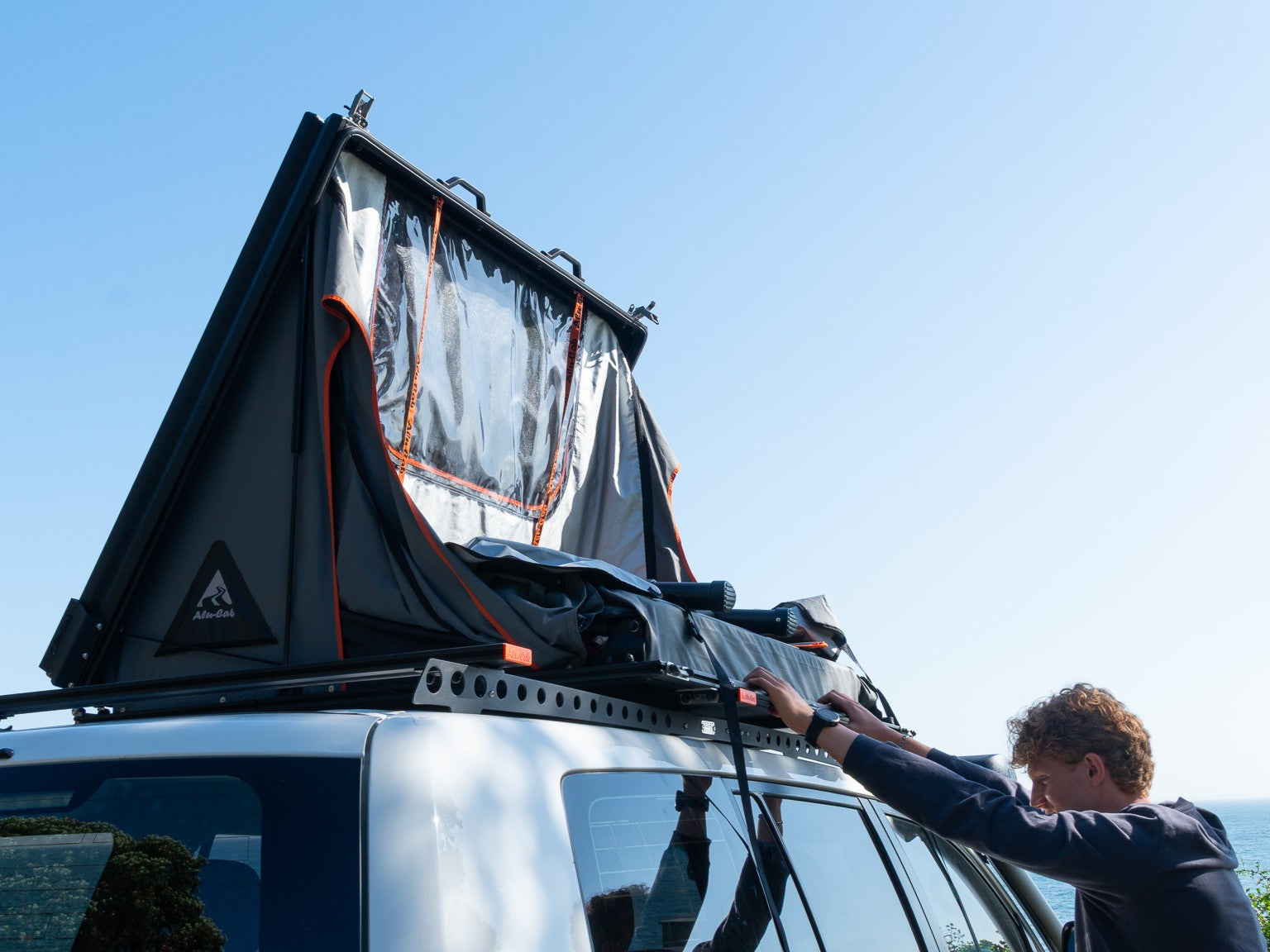 Tente de toit Alu-Cab RT-2S pour 2 personnes, coque en aluminium compacte, installation sur véhicule, vue de face.