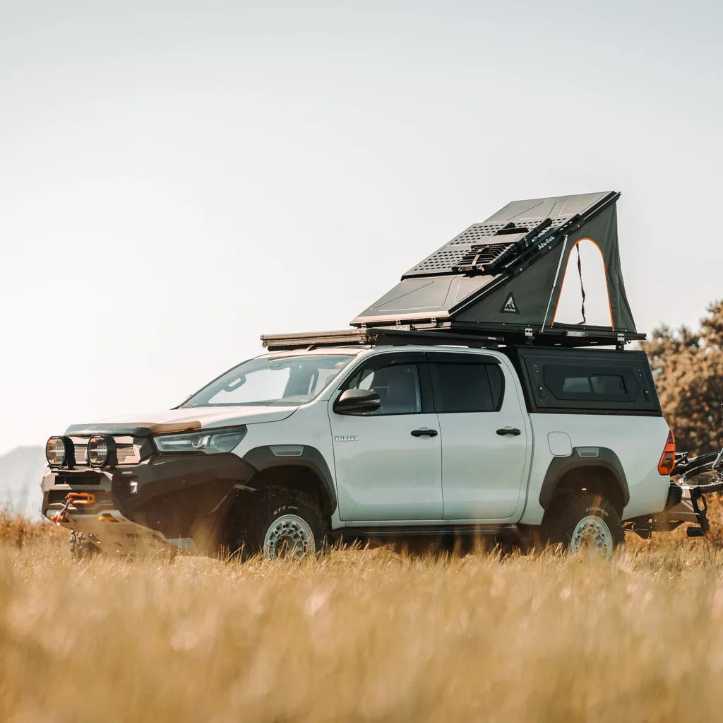 Tente de toit LT-50 Lightweight Alu-Cab en aluminium, installée sur un véhicule tout-terrain, ouverte avec fenêtre visible.