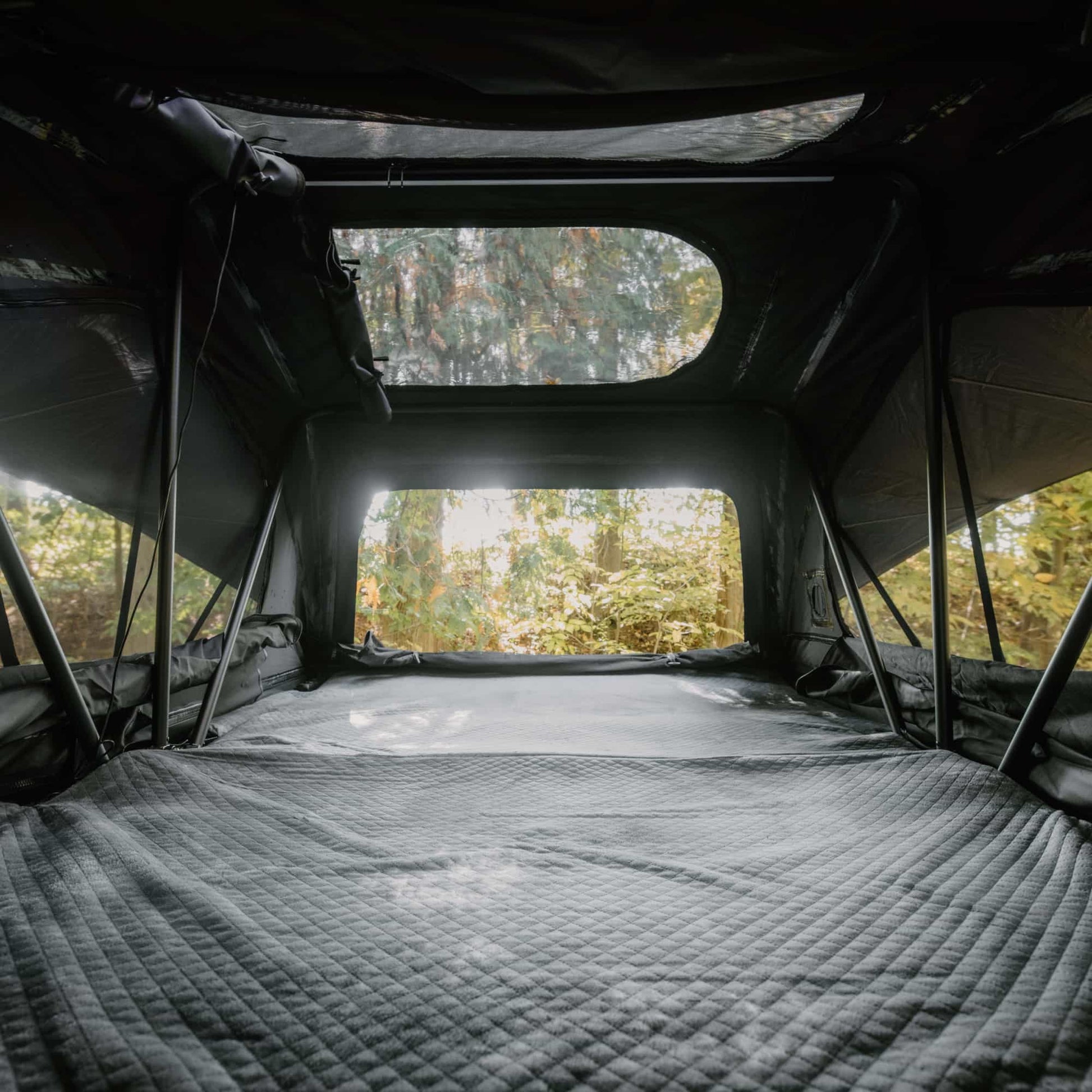 Tente de toit Voyage L GO OVERLAND CANADA pour 4 places, installation sur véhicule, tissu résistant et fenêtre zippée visible.