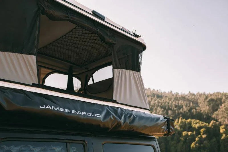 Tente de toit James Baroud Grand RAID M/X/XL, déployée sur un véhicule, en tissu résistant avec fenêtres et ouverture vers le ciel
