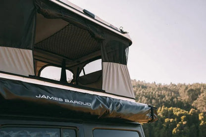 Tente de toit James Baroud Grand RAID M/X/XL, déployée sur un véhicule, en tissu résistant avec fenêtres et ouverture vers le ciel