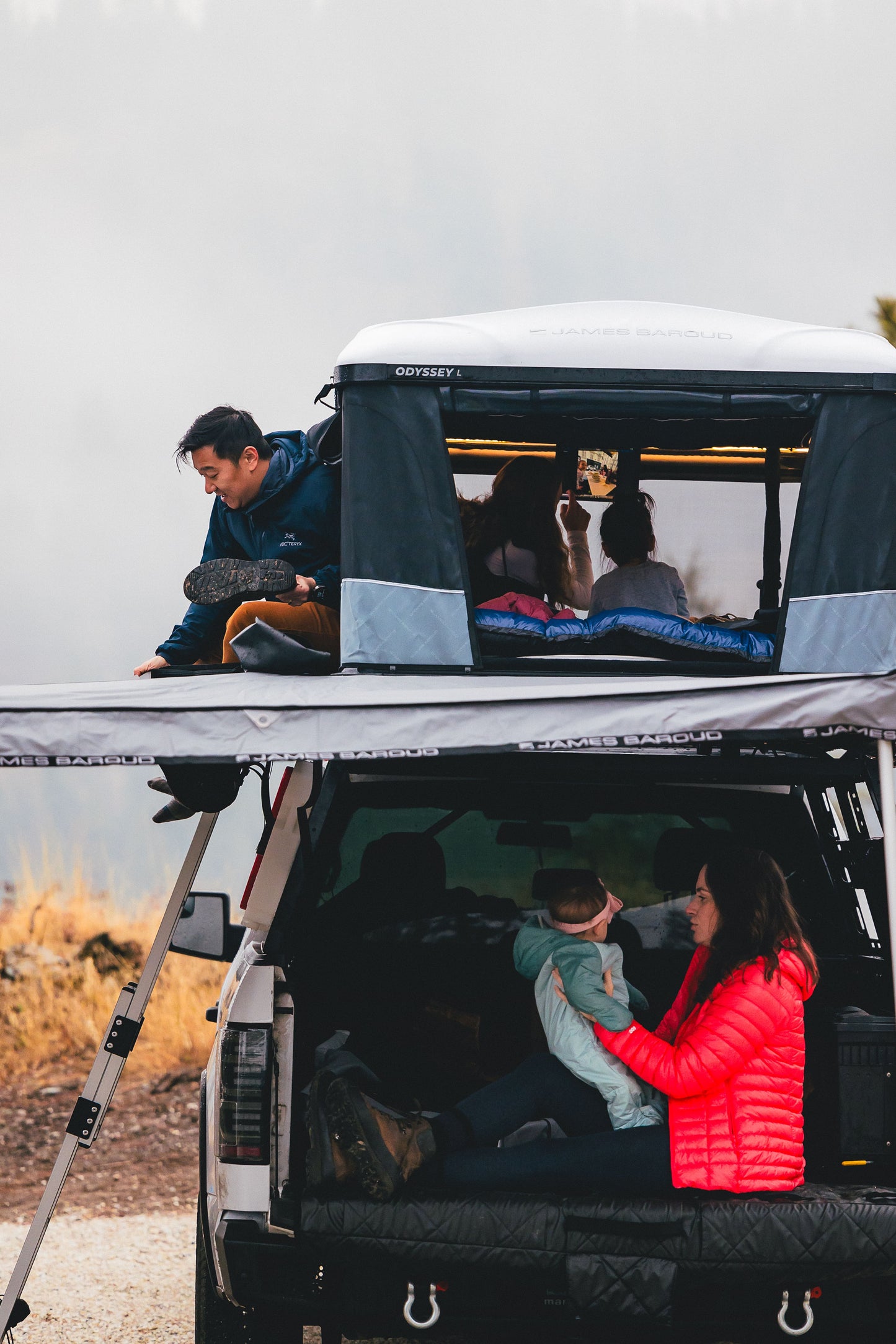 Tente de toit James Baroud Odyssey L, look noir, ouverte avec matelas confort, pour camping en plein air.