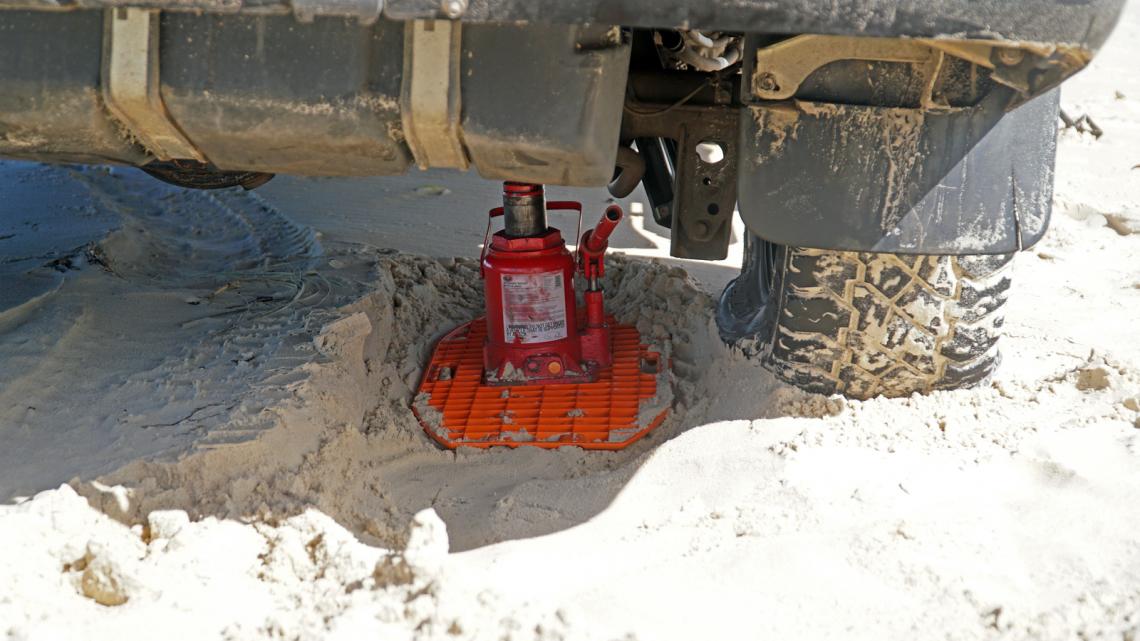 Plaque à sable Maxtrax Jaxbase, support cric ultra-résistant, conçue pour stabiliser les véhicules lors de travaux ou réparations.