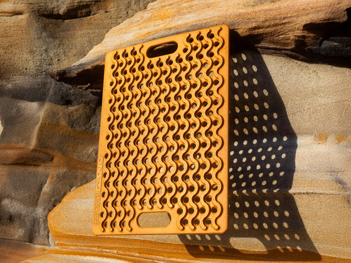 Tapis de douche extérieur ONTAP Mariner Mat beige pour camping et 4x4, avec jerrycan en toile de fond.