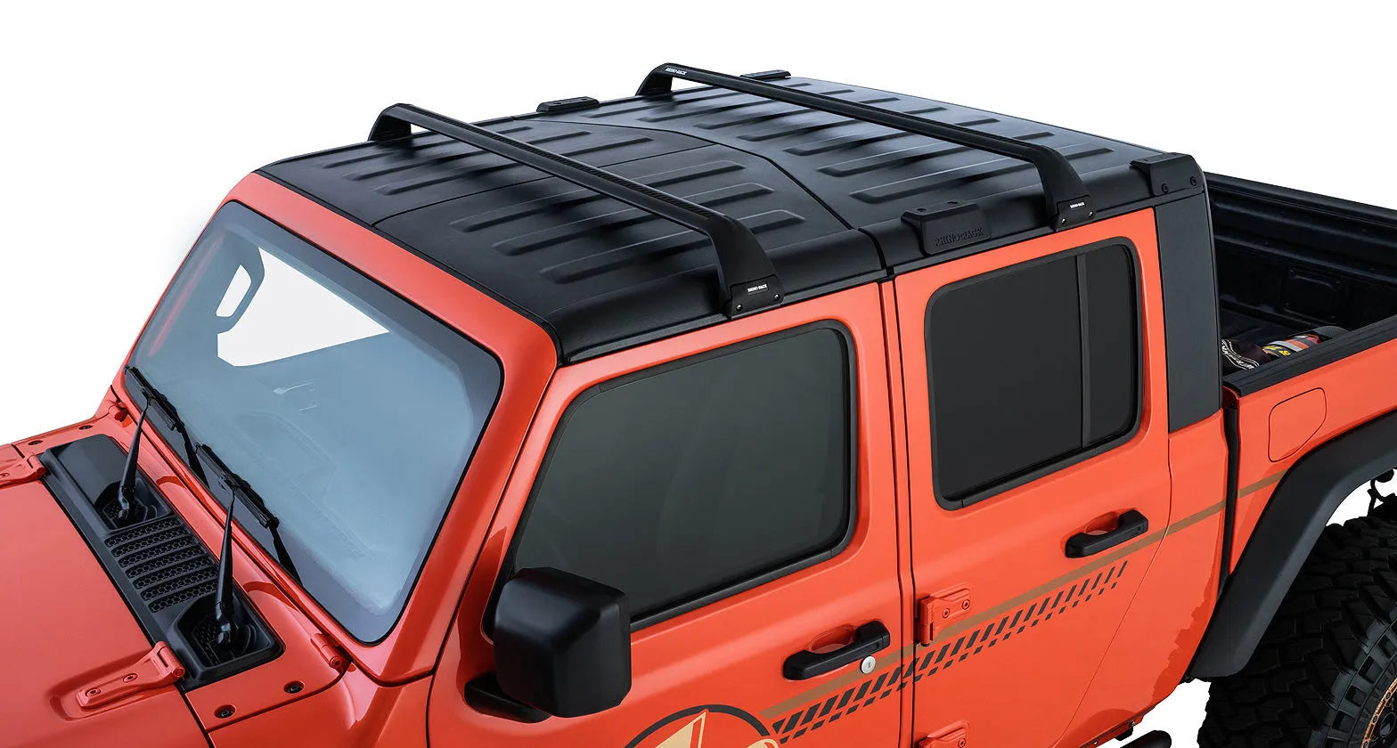 Kit de 2 barres de toit Vortex SG noires pour Jeep JK/JL/JT 4 portes de la marque RHINO-RACK, visibles sur le véhicule.