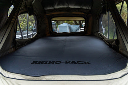 Tente de toit souple RHINO-RACK de 2100 x 1300 mm, installation sur véhicule, façade avec fenêtre et matériaux résistants.