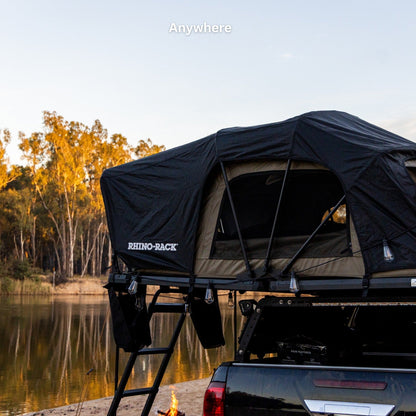 Tente de toit souple RHINO-RACK, 2100 x 1300mm, installée sur un véhicule, en tissu robuste pour camping et aventure.