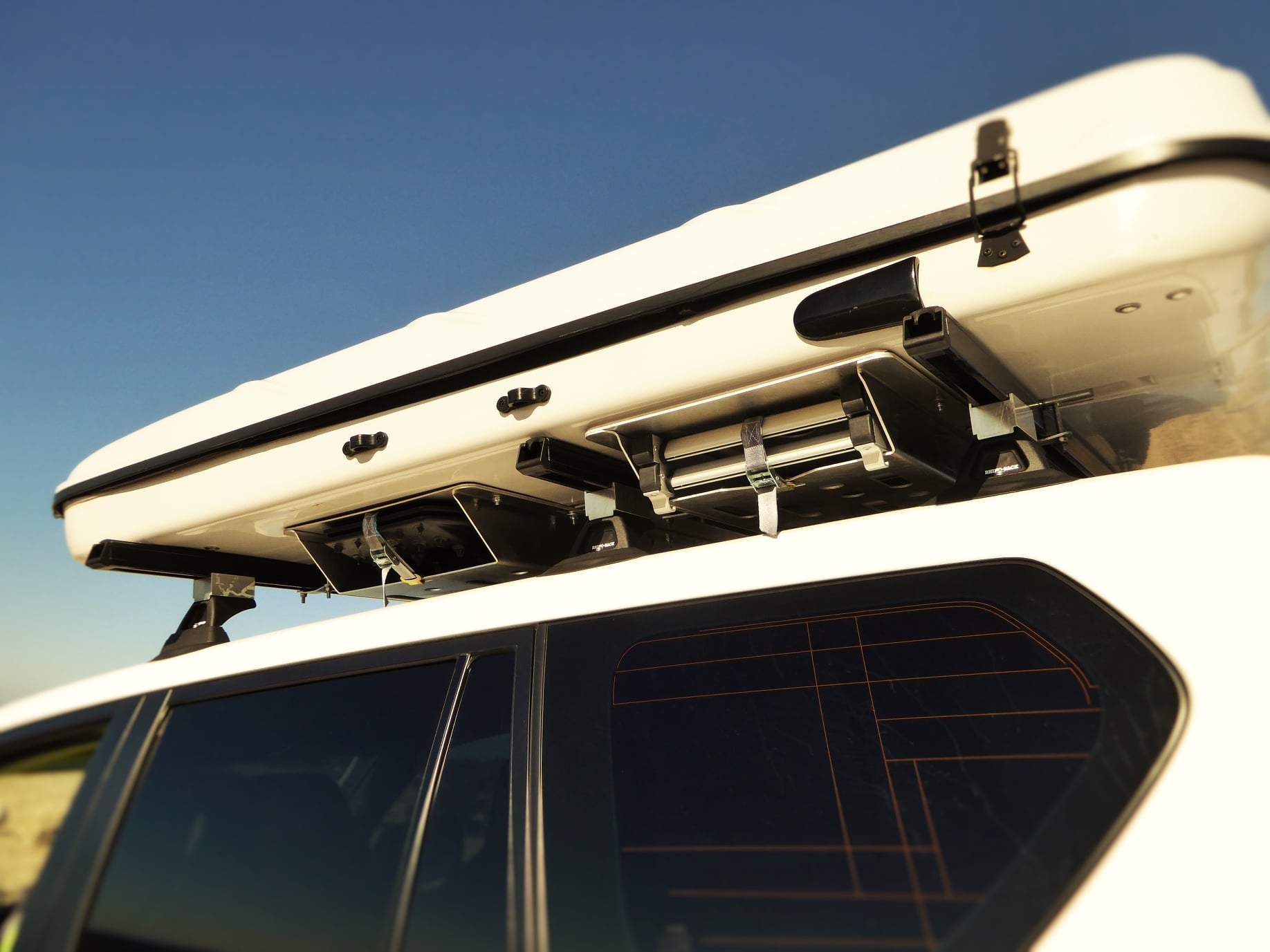 Support de plaques à sable Maxtrax N4 OFFROAD sous tente James Baroud, accessoire robuste pour véhicule tout-terrain.