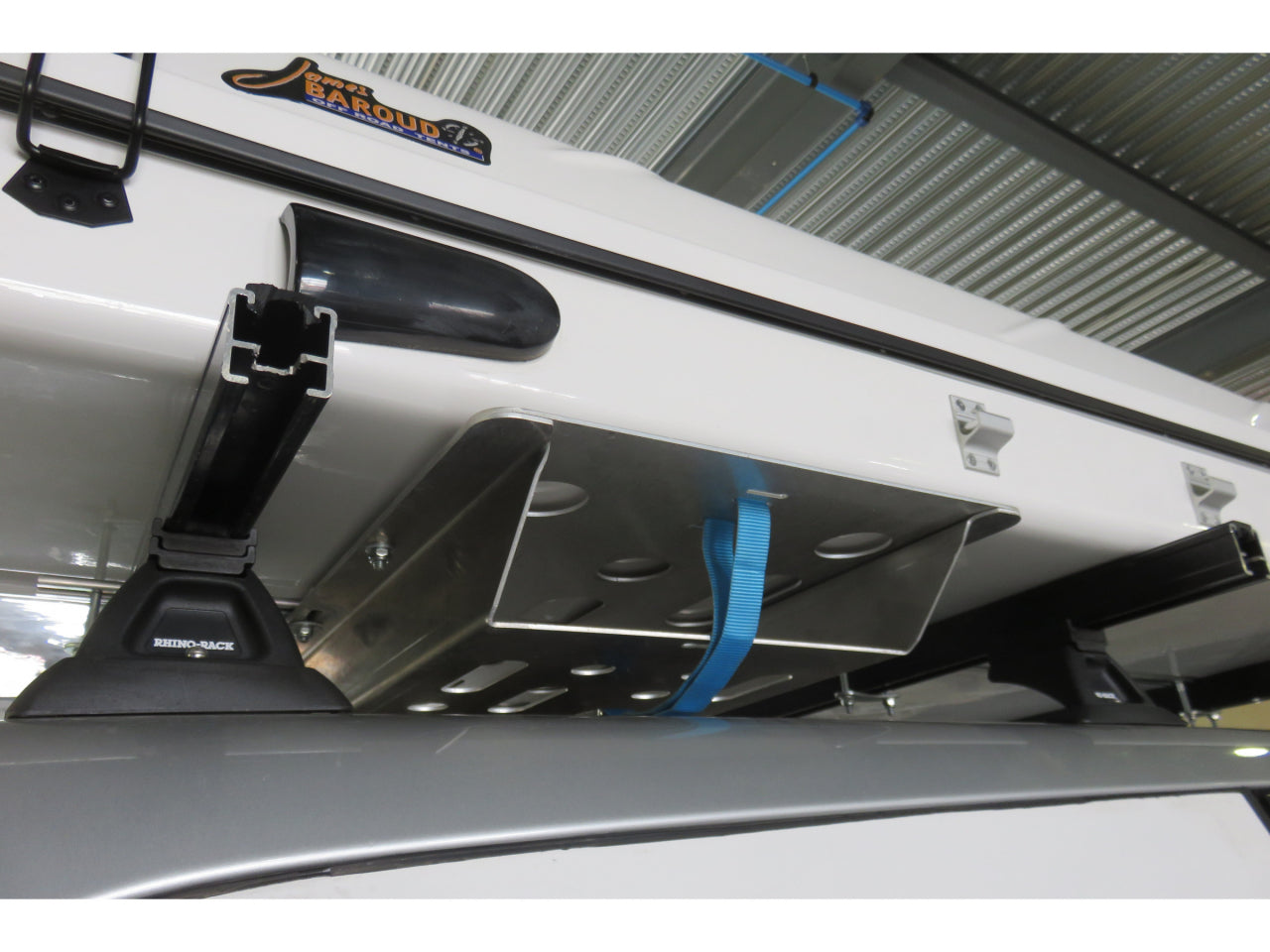 Support d'échelle pour tente de toit James Baroud N4 OFFROAD, accessoire robuste installé sous la tente pour sécuriser l'échelle.