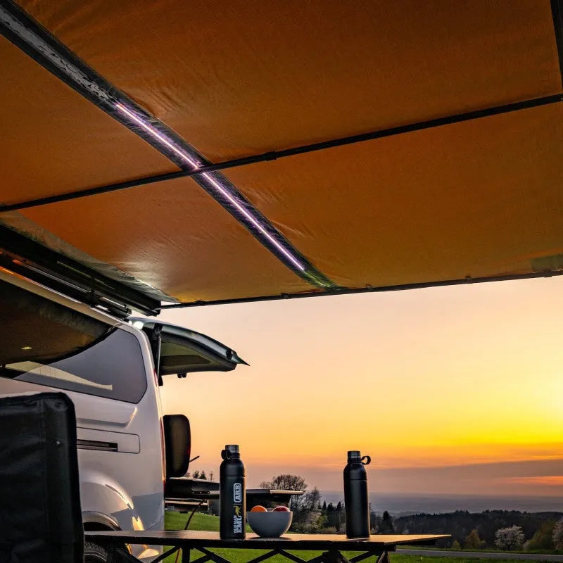Auvent ARB Black Edition 3000 x 2500 mm avec LED intégrée, installé sur un véhicule tout-terrain en extérieur.