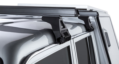 Kit de 2 barres de toit noires Heavy Duty 1500mm pour Toyota Land Cruiser série 79 2007+ avec pieds, par RHINO-RACK.