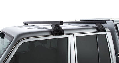 Kit de 2 barres de toit noires Heavy Duty 1500mm avec pieds RL110 pour Toyota Land Cruiser série 79 2007+ RHINO-RACK.