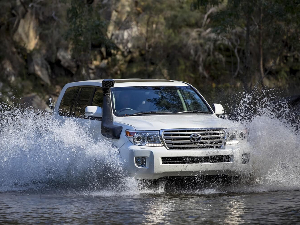 Snorkel Safari 4x4 Armax installé sur un Toyota Land Cruiser URJ200 2008-2015, vue de côté en situation tout-terrain.