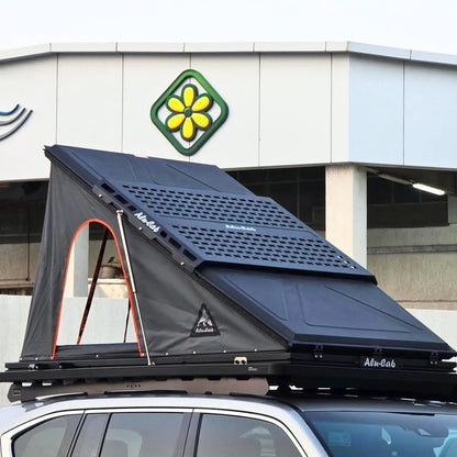 Tente de toit Alu-Cab LT-50 en aluminium légère pour camping, montée sur véhicule, avec fenêtre et matelas visible.