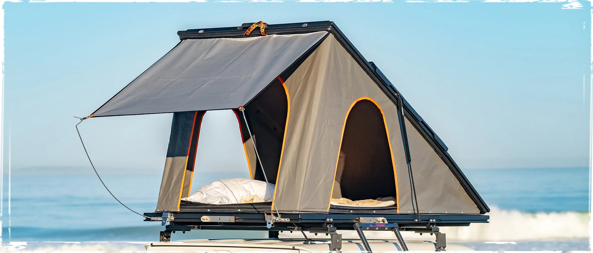 Tente de toit Alu-Cab LT-50 en aluminium légère, montée sur véhicule, avec matelas et fenêtres visibles.