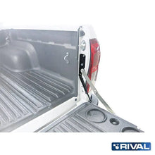 Verins d'assistance pour ridelle Toyota Hilux Revo, marque Rival 4x4, montrés fixés sur la ridelle du véhicule.